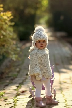 Bebek Menekşe oyuncak arabası park üzerinde haddeleme yolu. Kız Vintage bebek arabası ile güneşli günde yürüyüş. Rolü oyun oyun kavramı. Yürümeye başlayan çocuk örme giysiler açık havada oynuyor. Çocuk ve çocukluk yaşam tarzı.