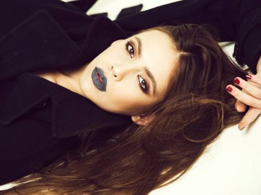 Kız paltolu güzel saç modeli ile siyah makyaj vardır