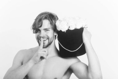 Bayan gün. Sakal veya seksi, kas maço, atlet, çıplak göğüs sessizlik parmak hareketi ve taze gül, gülümseyerek mutlu bir adam, siyah hediye kutusu beyaz duvar üzerinde çiçekler. Sürpriz ve tatil