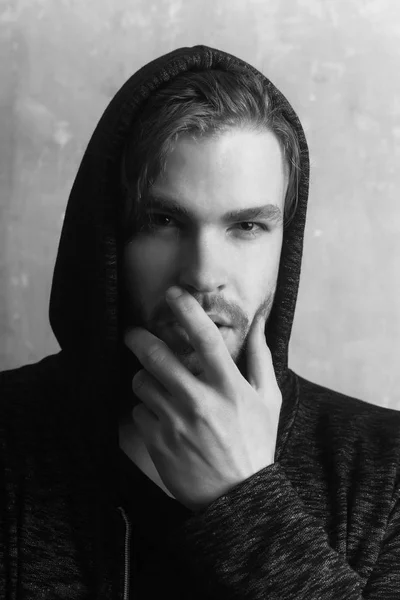 Young man hiding unshaven face with hand wearing grey hoodie — Stock Photo, Image