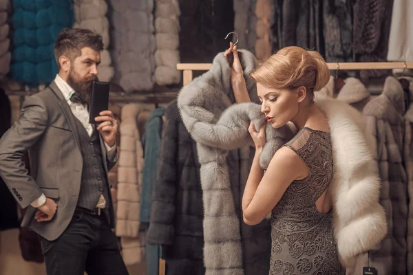 Woman in fur coat with man, shopping, seller and customer.