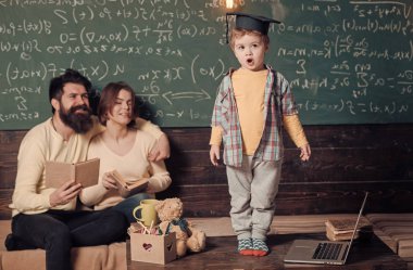 Kitap kara tahta arka plan ile hataları kontrol onların oğlu, dinleme anne. Sınav kavramı için hazırlanıyor. Çocuk Anne ve baba için onun bilgi sunma. Lisansüstü şapkalı akıllı çocuk gibi gerçekleştirmek için.