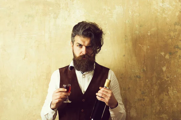 Homem segurando garrafa e copo de vinho — Fotografia de Stock