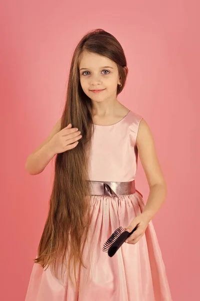 Menina criança escova de cabelo em vestido elegante em rosa . — Fotografia de Stock