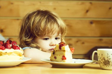 küçük çocuk çilekli kek yiyor