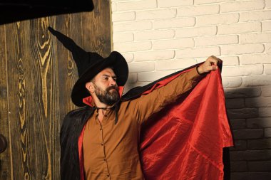 Cadılar Bayramı adam kırmızı Sihirbazı pelerin ve Kara Cadı şapka poz. Eğlence ve fantezi kavramı.