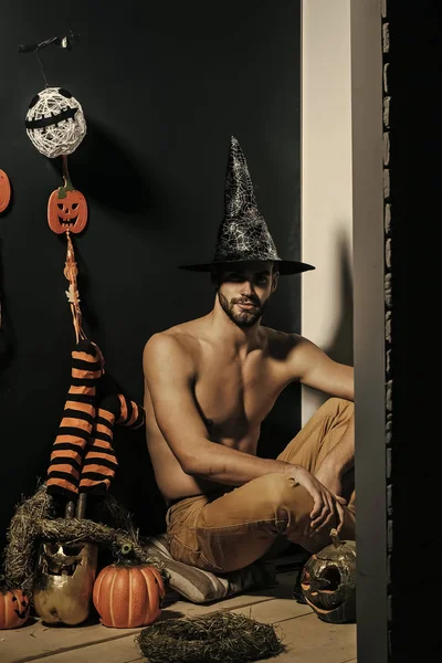 Halloween macho con cappello da strega e busto scoperto seduto — Foto Stock