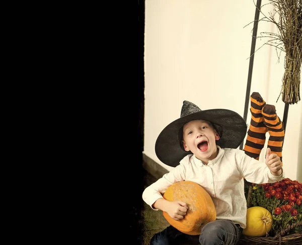 Halloween niño con calabaza naranja en sombrero de bruja —  Fotos de Stock
