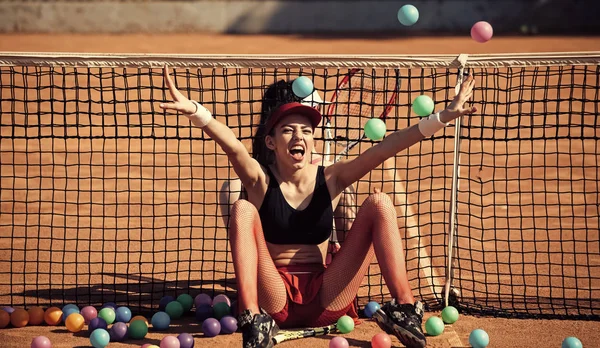 Idrottskvinnor sitta på tennis netto och kasta bollar — Stockfoto