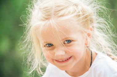 Özgür ve mutlu hissediyorum. Küçük kız giyim saç bezleri. Sarı saçlı küçük kız. Çok güzel gülümseme ile mutlu küçük çocuk. Küçük çocuk mutlu gülümseyerek. Benim saç değiştirme seviyorum