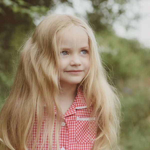Haarpflege. glückliches kleines Kind mit entzückendem Lächeln. kleines Mädchen trägt lange Haare. kleines Mädchen mit blonden Haaren. kleines Kind glücklich lächelnd. das Geheimnis einer glücklichen Kindheit — Stockfoto