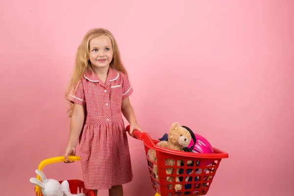 Shopping is a bit of a relaxing hobby for me. Little girl shopping. Little shopaholic with shopping cart. Small girl in shop. Small shopper. Kind of girl restyled in a retro way — Stock Photo, Image