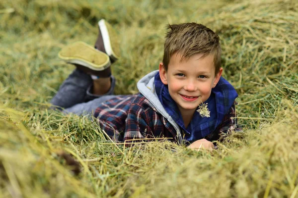 La agricultura está en mi corazón. Pequeño niño, relájate en el pajar. El niño disfruta del tiempo libre en el campo. Sé orgánico y natural. Devolver la diversidad a la agricultura — Foto de Stock