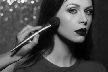 Profesyonel makyöz güzel genç bir kadınla çalışıyor.