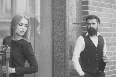 Elinde şarap şişesi olan hippi kapıyı açan kadına bakıyor.