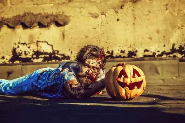 Zombie man lies on pumpkin — Stock Photo, Image