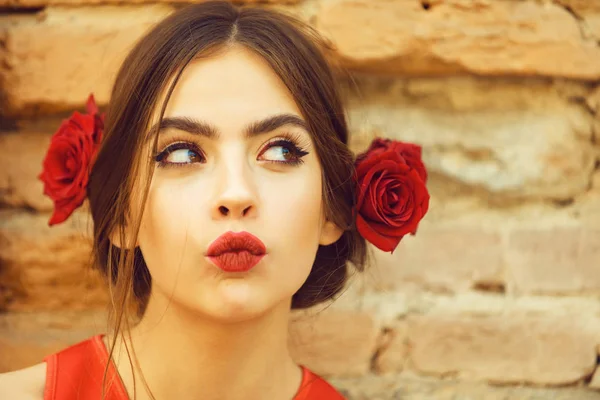 Περίεργη γυναίκα με κόκκινα χείλη και φρέσκα τριαντάφυλλα στα μαλλιά — Φωτογραφία Αρχείου