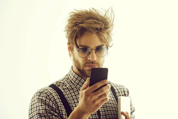 Handsome man in eyeglasses with smartphone and laptop computer