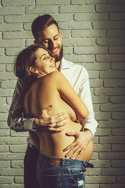 Barbudo hombre y bonita mujer embarazada con desnudo vientre redondo — Foto de Stock