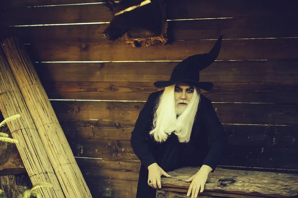 Старий чарівник біля дерев'яних скриньок або коробки стовбура — стокове фото