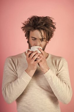 Soğuk algınlığı ve grip, tek. Uykusuzluk, ferahlık ve enerji. Çay bardağı pembe bir arka plan üzerinde uykulu adamla. Sabah kahve veya süt ile. Dağınık saçlı adam mulled şarap içmek.