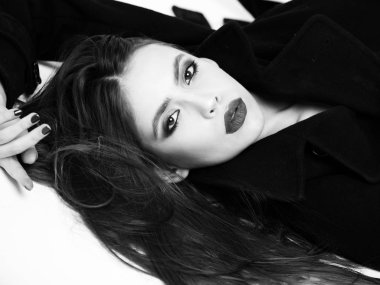 Kız paltolu güzel saç modeli ile siyah makyaj vardır