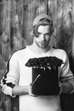 adam tutar kırmızı gül çiçekler kutusunda sakallı