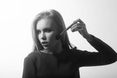 Kırmızı dudaklar toz yüz cilt makyaj fırçası ile uygulayarak olan kadın. Sevimli kız beyaz izole mavi elbiseli sarışın uzun saçlı. Moda modeli. Moda. Sima, makyaj, kozmetik ve Cilt Bakımı