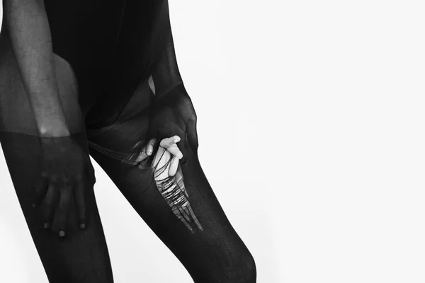 Punčocháče nebo roztrhané černé nylonové punčocháče na nohou ženy — Stock fotografie