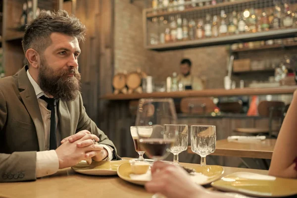 Date or business meeting of hipster in pub. Confident bar customer speak in cafe. Businessman with long beard in cigar club. Business on go and communication. Bearded man in restaurant with companion