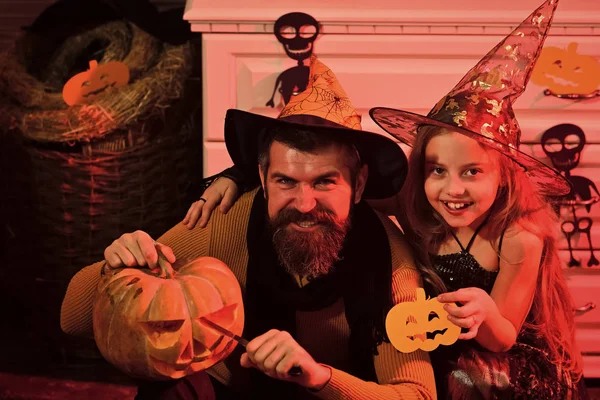 Wizard and little witch with Halloween decor.