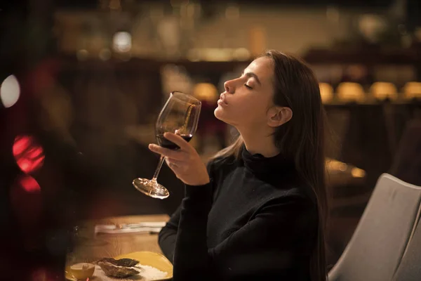Pretty woman rest in restaurant with wineglass. Perfect wine. bar customer sit in cafe drinking alcohol. girl with long hair drink red wine. Date meeting of woman taster awaiting in pub. — Stock Photo, Image