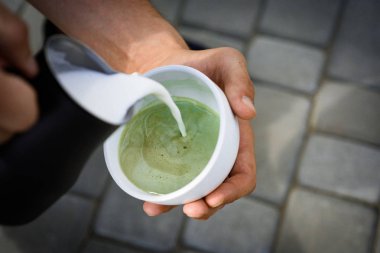 mükemmel sabah yeşil kahve ile. Matcha sütlü çay töreni, pour süt. Barista Japon çay içecek süt dökün. kafe veya kahve dükkanı ve içme rahatlayın. Ne harika bir sabah. Daha fazla süt