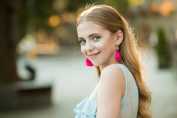 Belleza y look de moda de modelo. mujer feliz con maquillaje elegante y pelo largo y rubio. mujer de moda de verano. La moda es su vida. Linda chica con el pelo de moda y pendientes de color rosa. Mujer perfecta —  Fotos de Stock