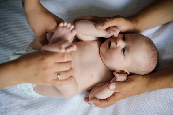 Ανακουφιστική φροντίδα. Νεογέννητο μωρό απολαύσετε θεραπεία ασκήσεις. Φροντίδα του νεογέννητου σώματος και φυσικοθεραπεία. Μωρό αγόρι ή κορίτσι δώσει φροντίδα σώματος — Φωτογραφία Αρχείου