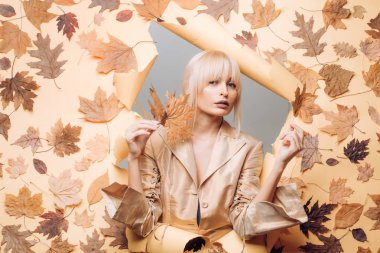 Mutlu genç kadın için sonbahar güneşli gün hazırlıyoruz. Bir mevsimlik giysiler whith altın varak çekici genç kadın. Sonbahar ruh hali ve hava sıcak ve güneşli ve yağmur mümkündür. Sonbahar konsepti.