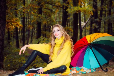 Sonbahar güneşli parkta mutlu genç kadın. Parkta eğleniyor ve gülümseyen sonbahar kadını. Moda sonbahar portre kadınla sarı akçaağaç doğa arka plan üzerinde bırakır. Romantik kız sanat çalışmaları.