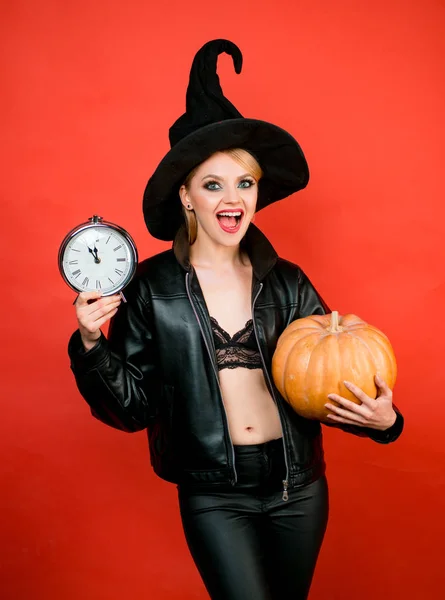 楽しいハロウィンをお過ごし下さい。赤い背景の上に黒い魔女ハロウィーンの衣装の若い女性。変な顔と驚きの女性. — ストック写真