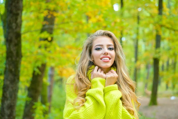 Dromerige meisje met lang haar in gebreide trui. Schattig meisje in goede stemming poseren in herfstdag. Mooie mode vrouw in het najaar rode jurk met vallende bladeren over de achtergrond van de natuur. Concept van de vrijheid. — Stockfoto