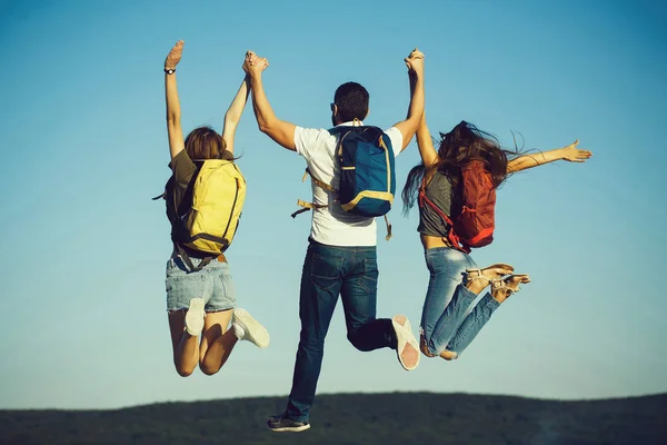 Tres amigos saltando en la cima de la montaña en el cielo azul —  Fotos de Stock