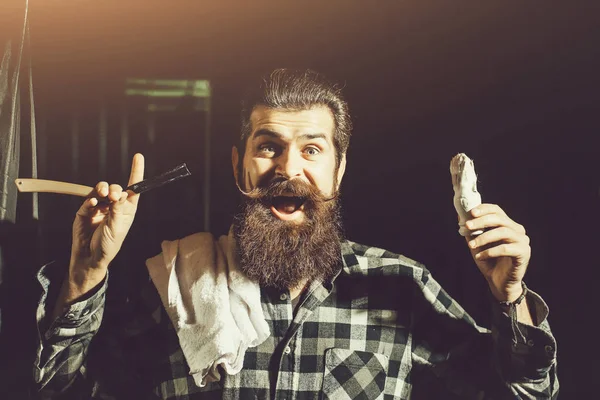 Bearded man shaves with razor