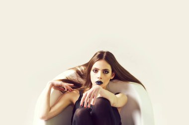 Uzun saçlı bir kadın, banyoda siyah ruj.