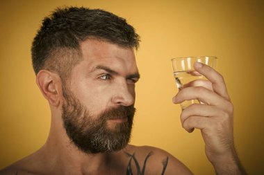 Uzun sakallı adam tutun su bardağı Sarı zemin üzerine.