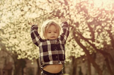İle ekose mavi gömlekli erkek bebek eller havaya