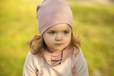 Yeşil çimenlerin üzerinde sevimli yüzü ile kız