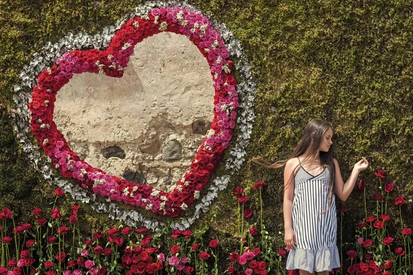 Fille pose au coeur floral sur le mur vert — Photo