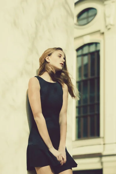 Chica bonita en vestido negro de moda en la pared del edificio —  Fotos de Stock