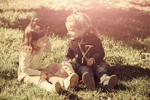 Frère et sœur assis sur l'herbe verte — Photo