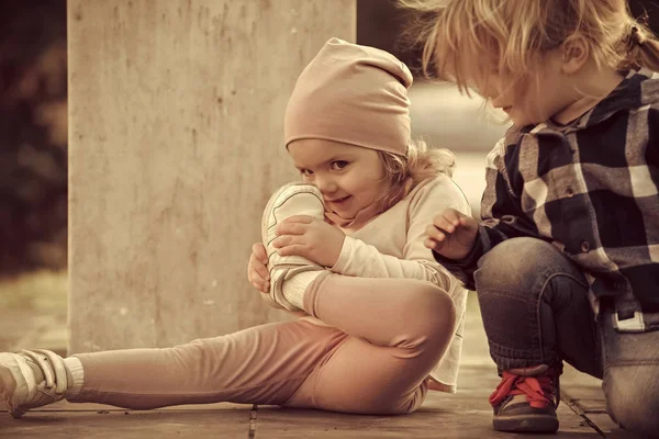 Jongen meisje touch neus met sport schoen kijken — Stockfoto