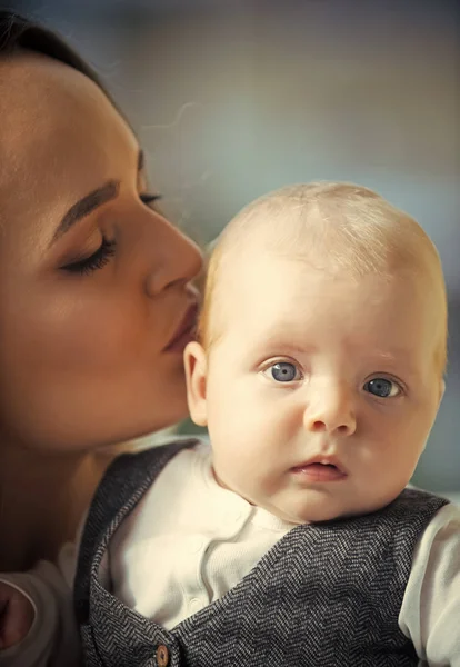 Mother kiss child son with blue eyes on adorable face — Stock Photo, Image